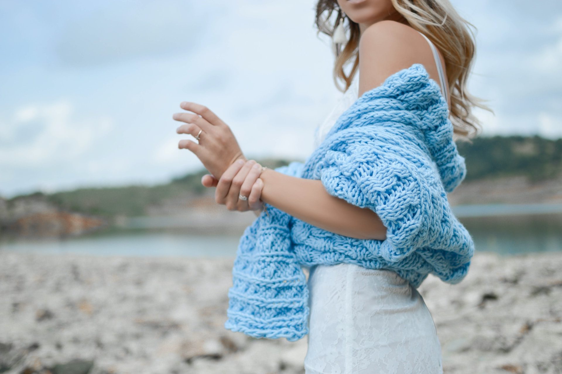 woman wearing teal crochet top and white skirt